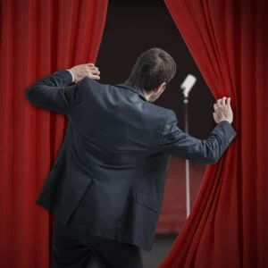 Image illustrant un homme qui ouvre des rideaux vers une salle de type théâtre
